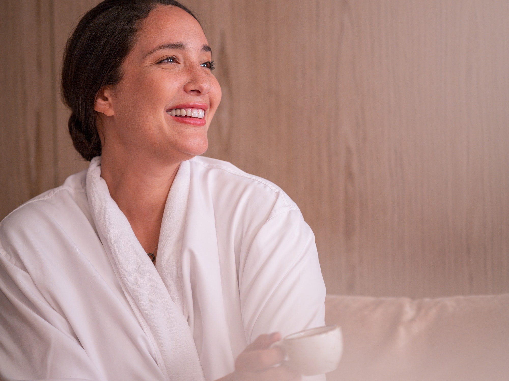 a woman in a white robe holding a cup