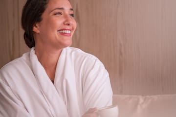 a woman in a white robe holding a cup