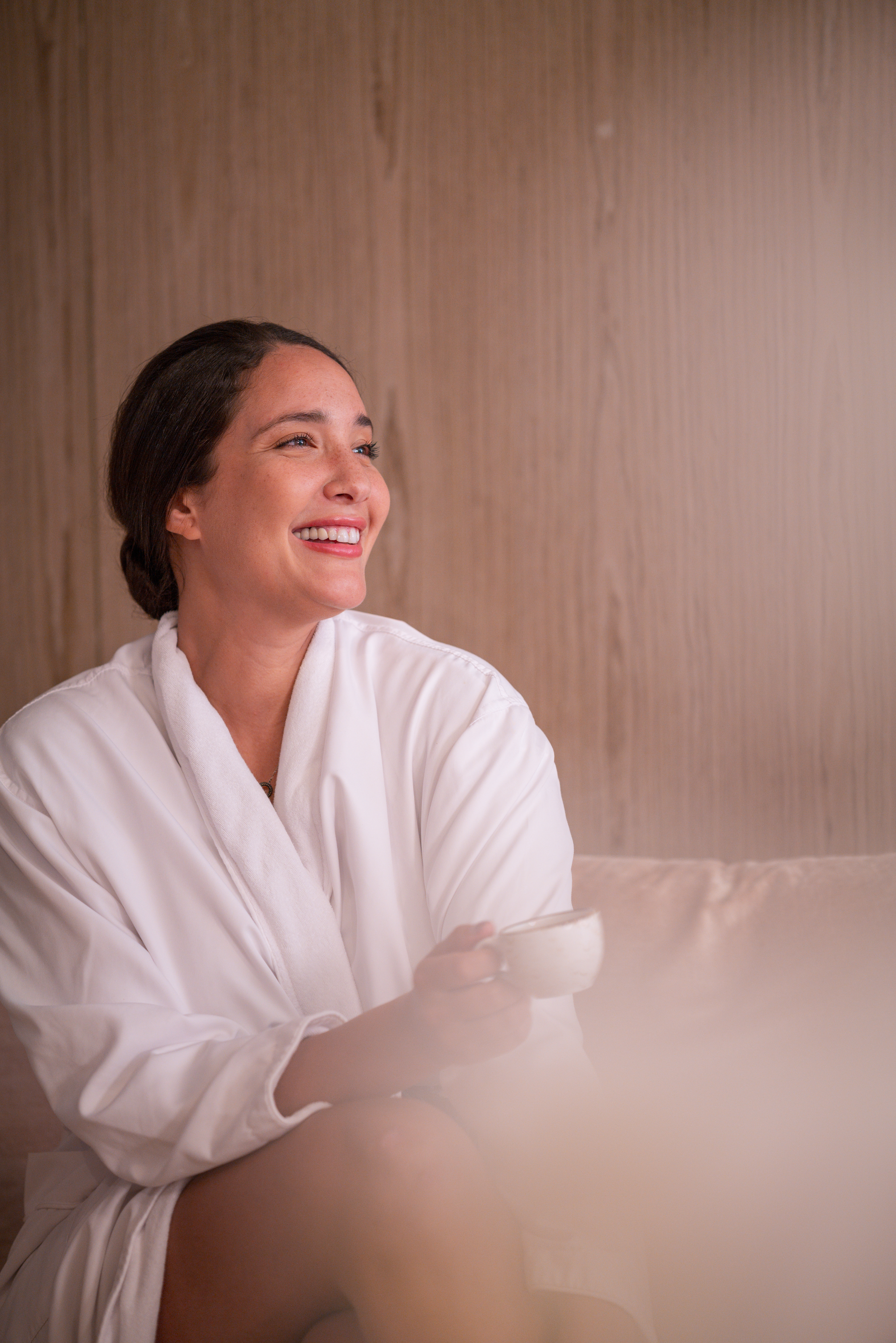 a woman in a white robe holding a cup