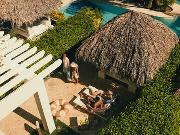 a group of people on lounge chairs by a pool