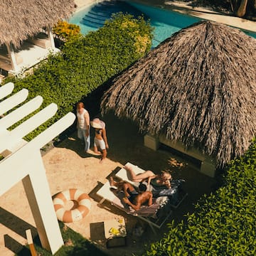 a group of people on lounge chairs by a pool
