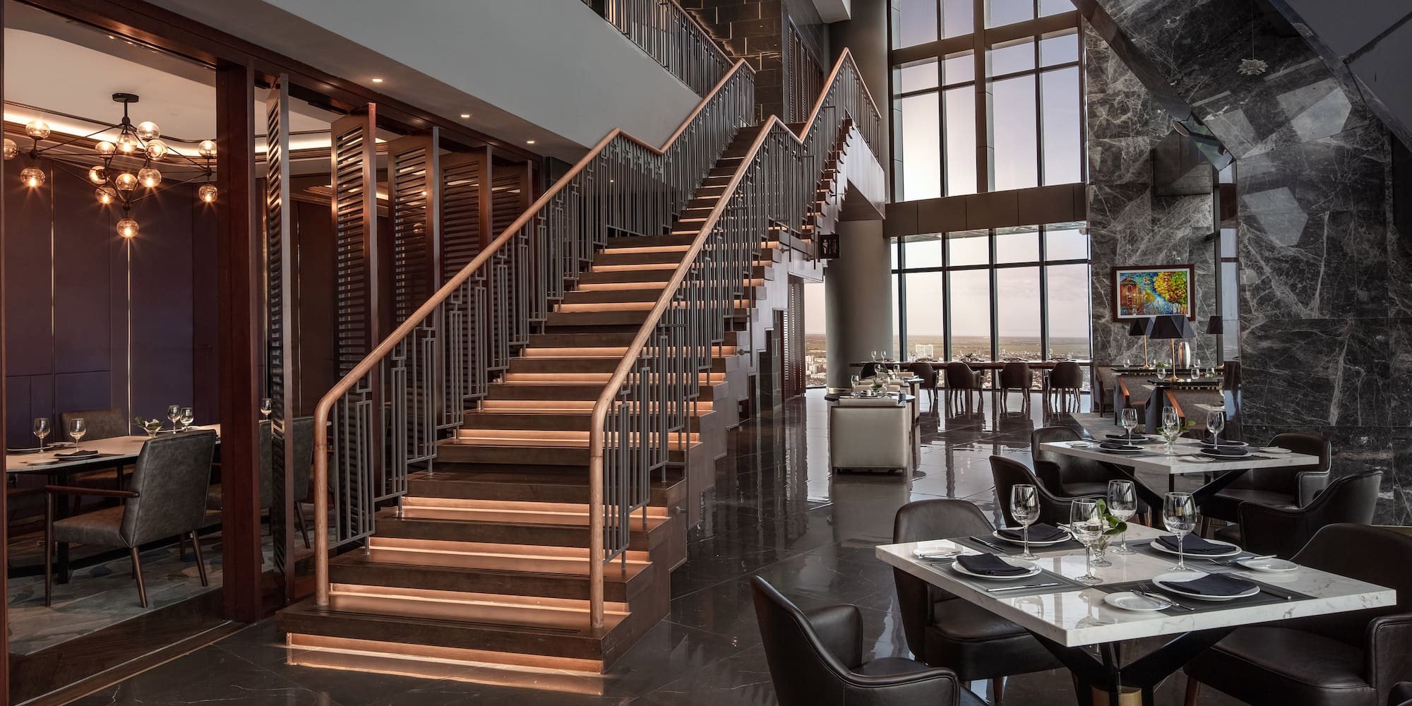 a restaurant with a staircase and tables