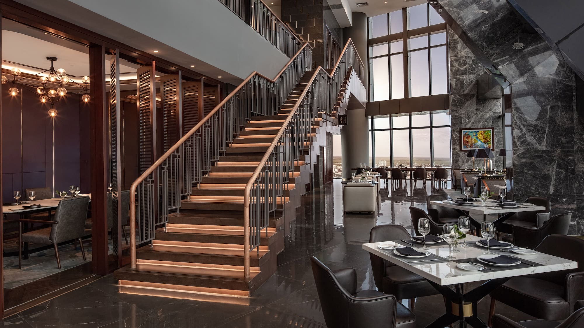 a restaurant with a staircase and tables