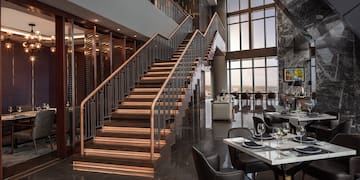 a restaurant with a staircase and tables