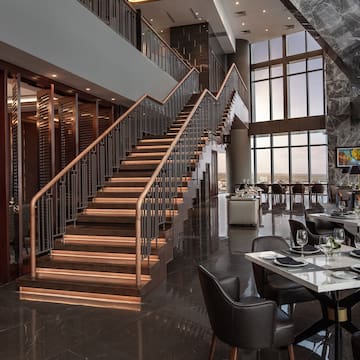 a restaurant with a staircase and tables