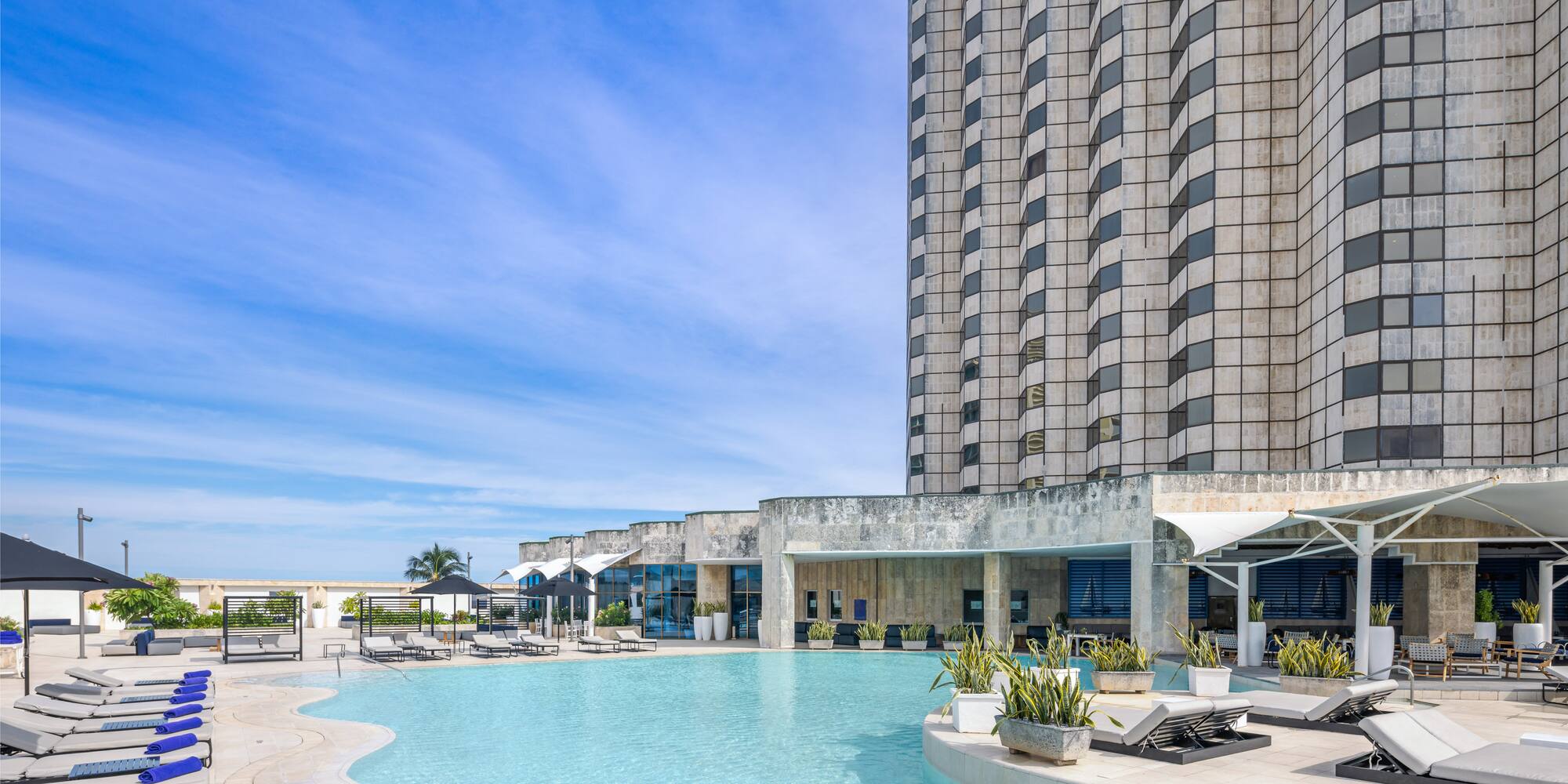 a pool with lounge chairs and a building in the background