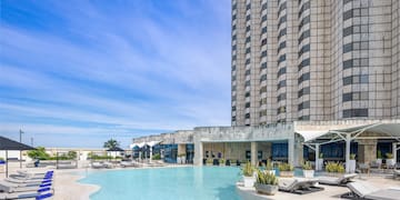 a pool with lounge chairs and a building in the background