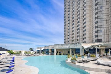 a pool with lounge chairs and a building in the background