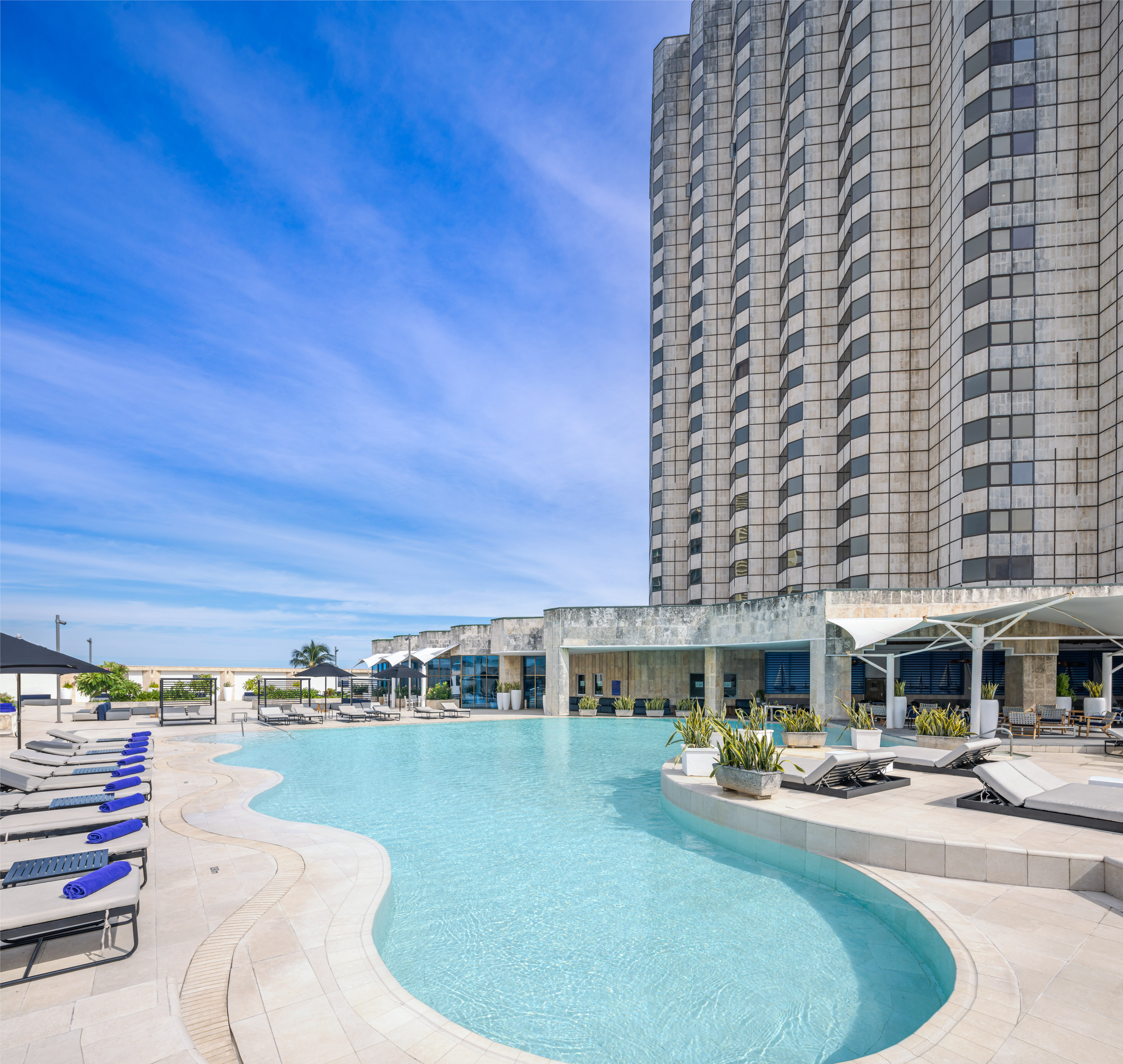 a pool with lounge chairs and a building in the background