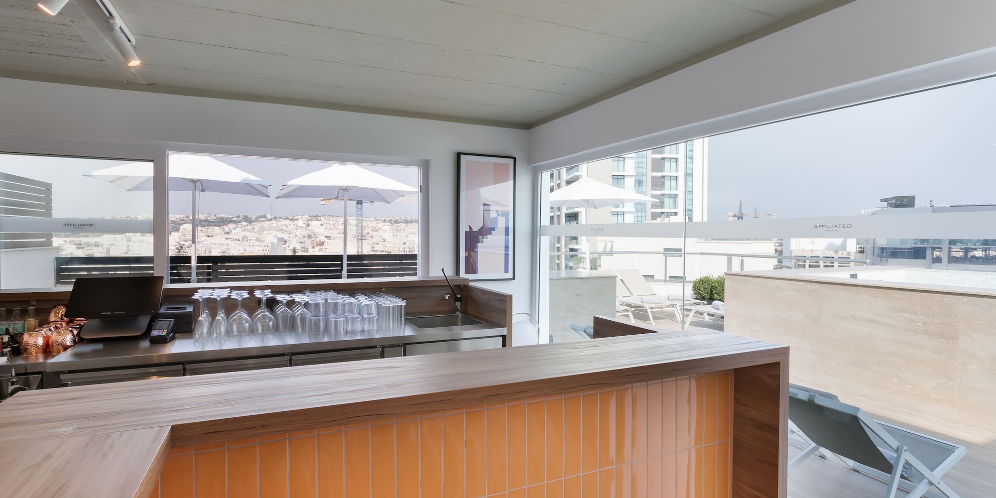 a bar with a counter and a table with chairs and umbrellas