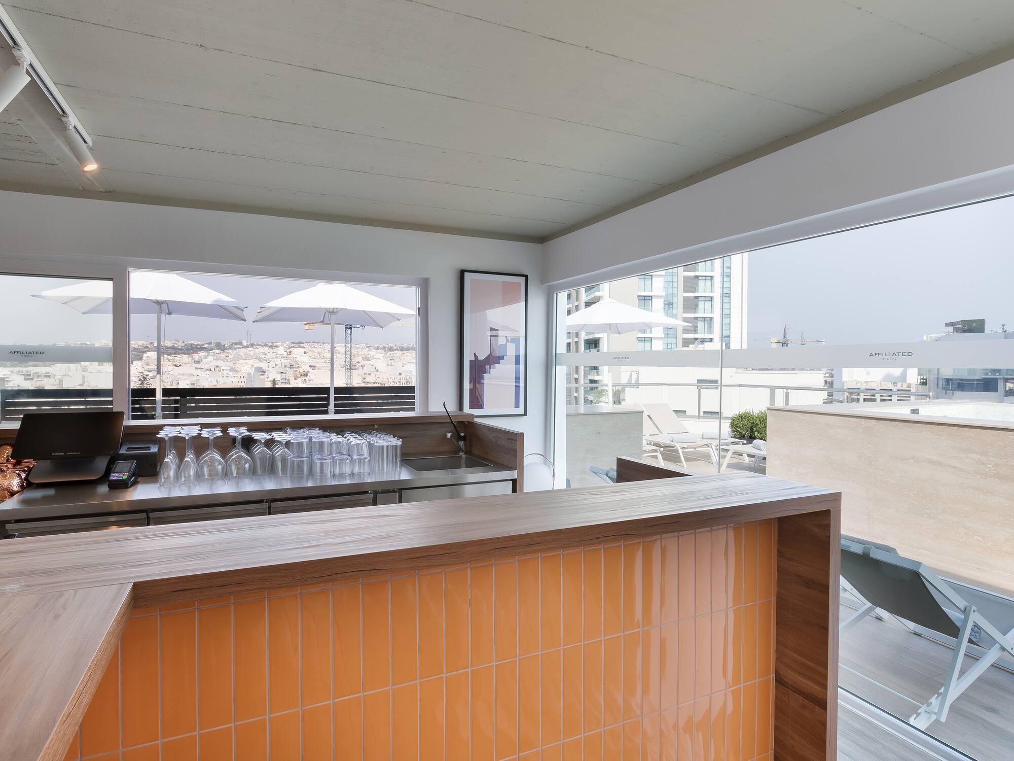 a bar with a counter and a table with chairs and umbrellas