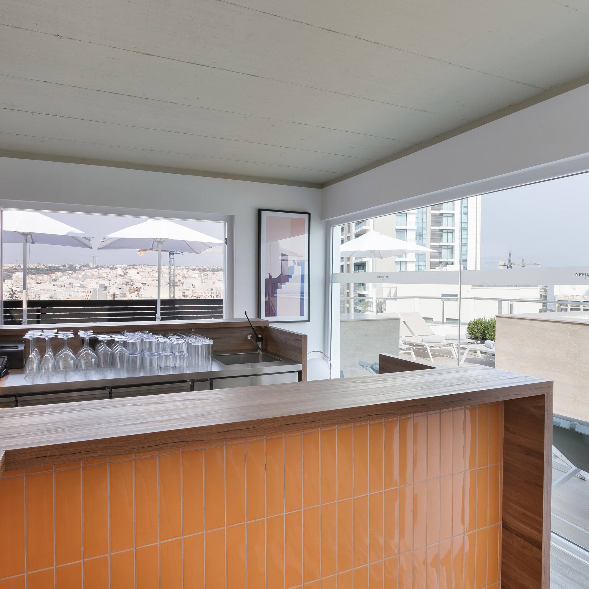 a bar with a counter and a table with chairs and umbrellas