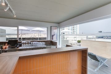 a bar with a counter and a table with chairs and umbrellas