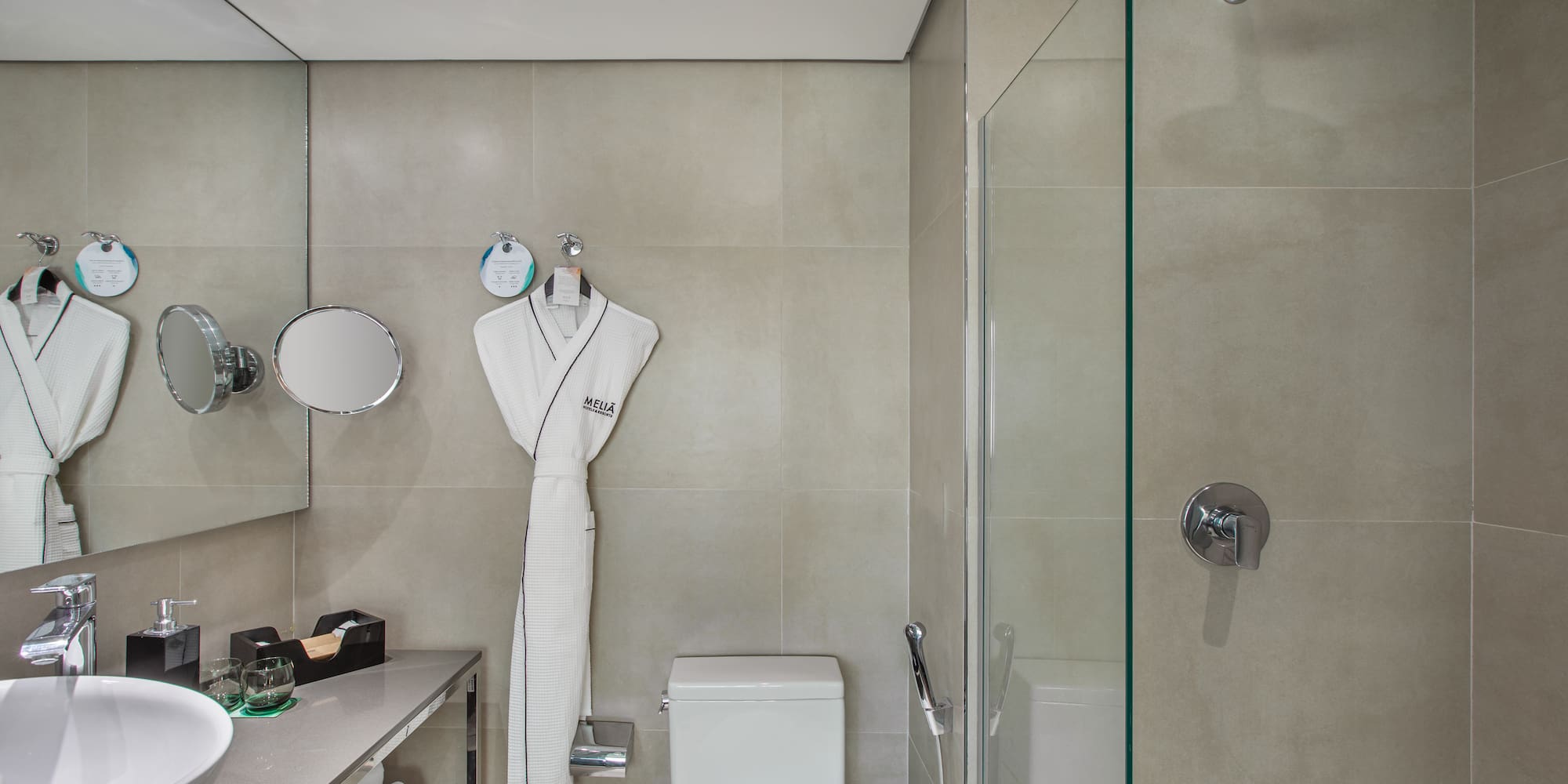 a bathroom with a white robe and a shower
