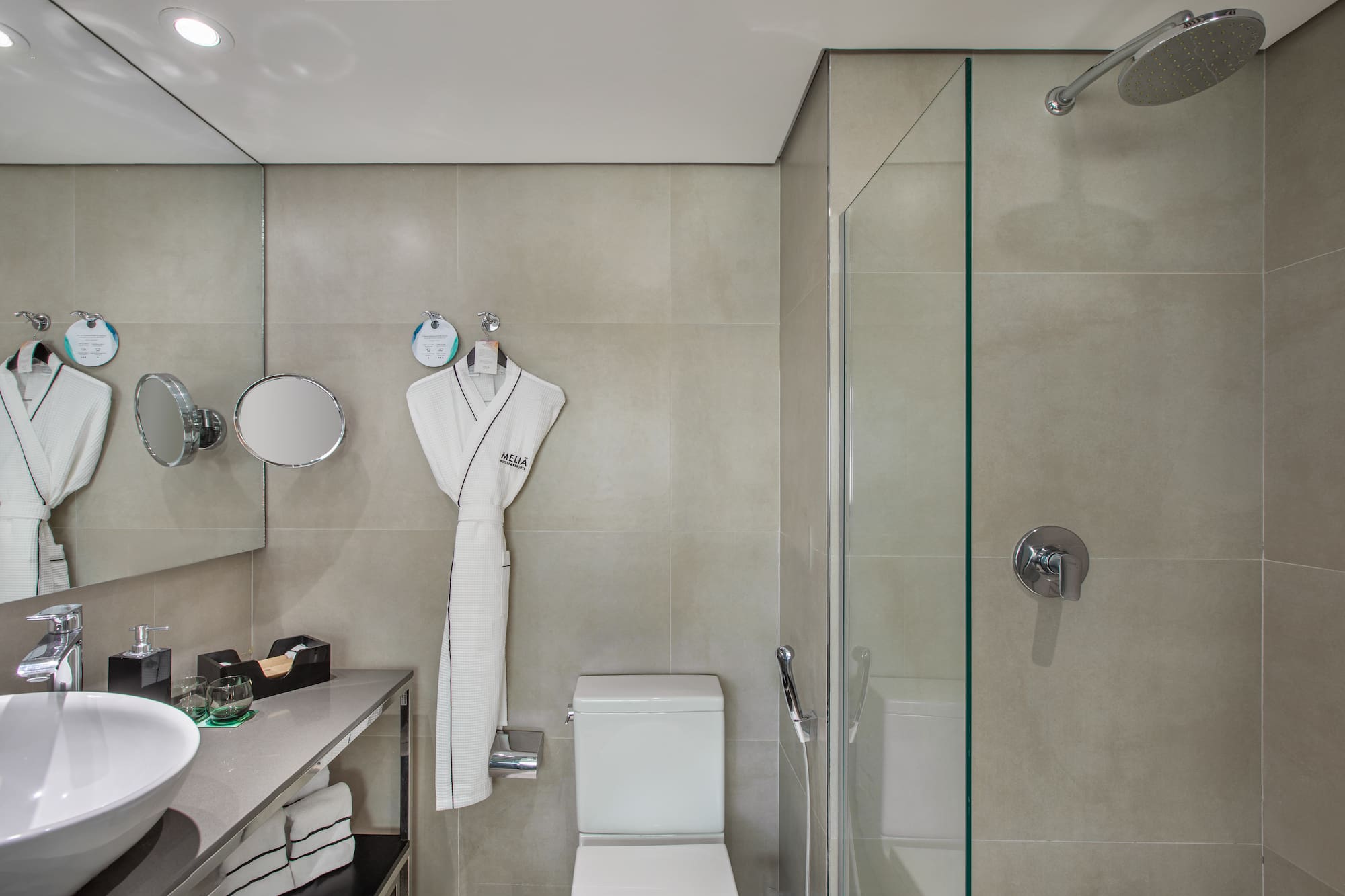 a bathroom with a white robe and a shower
