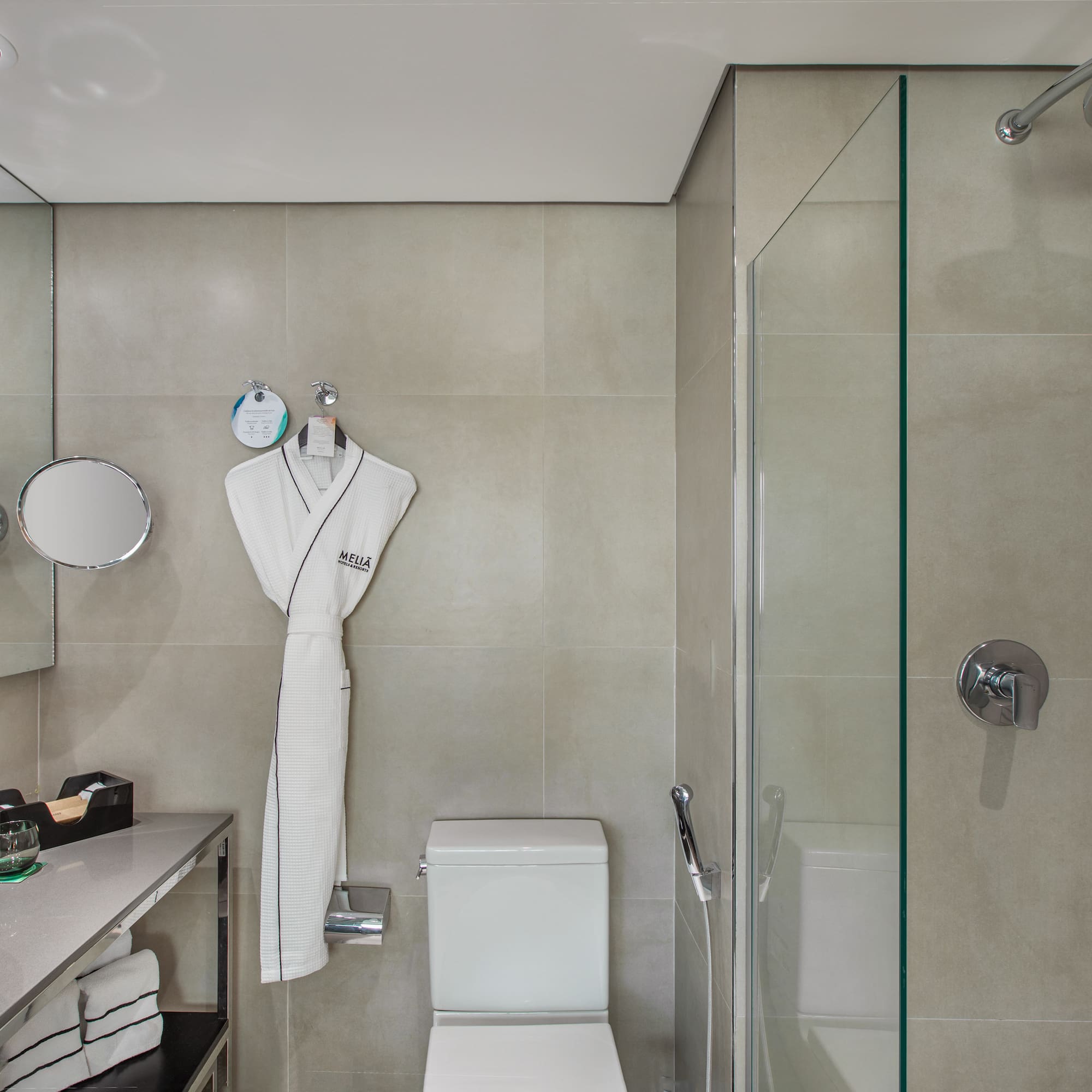 a bathroom with a white robe and a shower