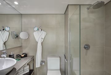 a bathroom with a white robe and a shower