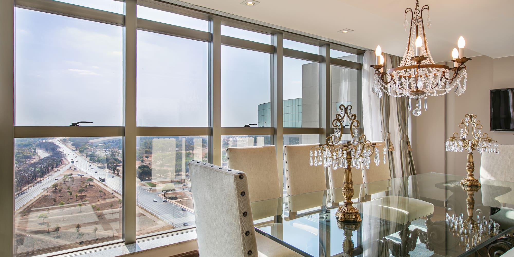 a dining room with a chandelier and glass table
