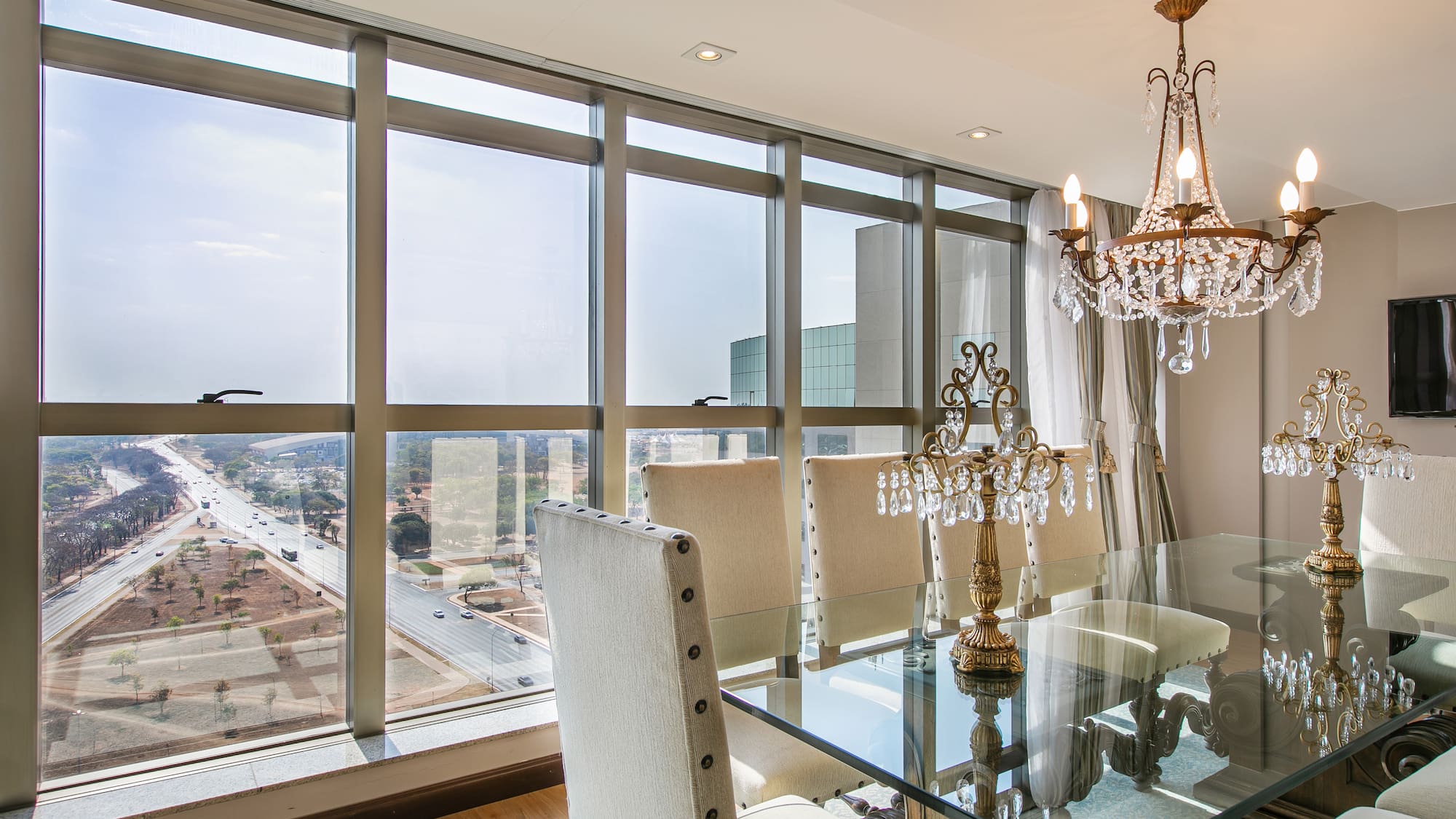 a dining room with a chandelier and glass table