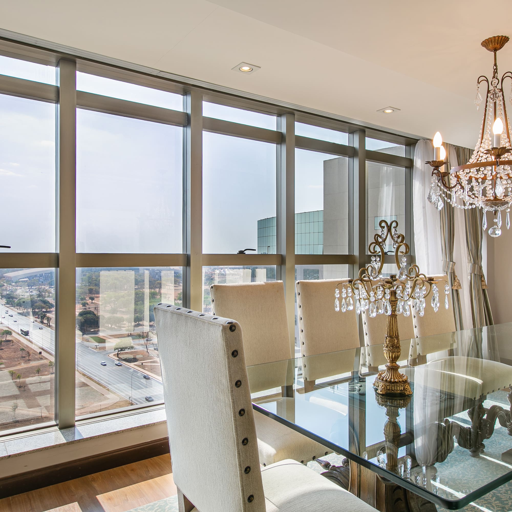 a dining room with a chandelier and glass table