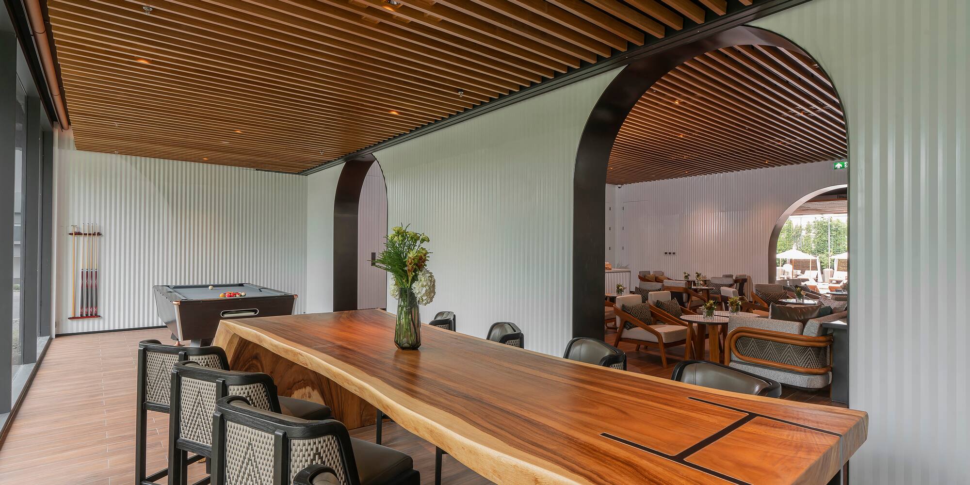 a room with a pool table and chairs