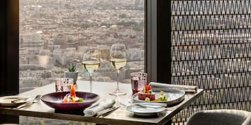 a table with plates of food and glasses of wine