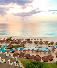 a pool and umbrellas on a beach