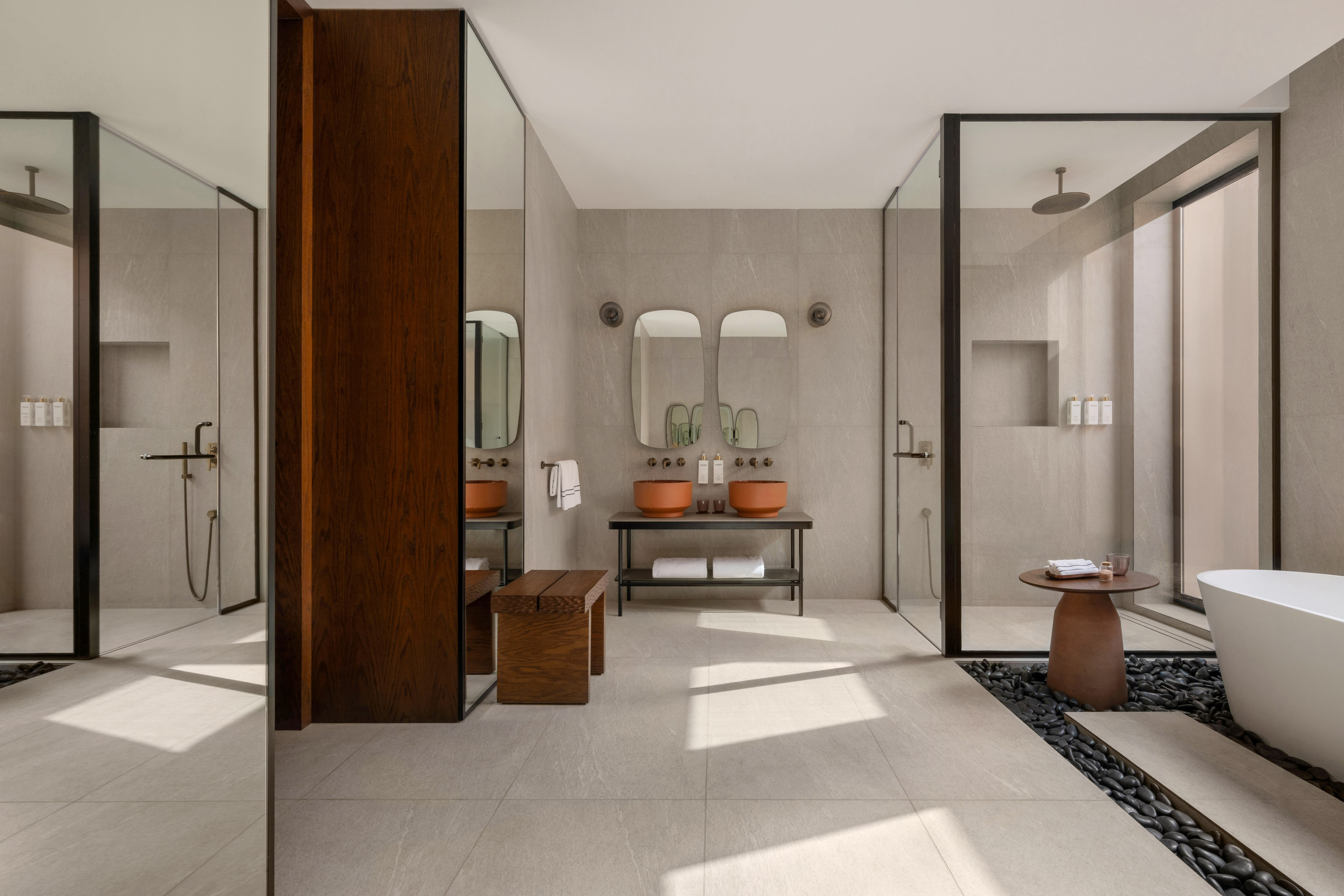 Modern luxury bathroom with terracotta sinks, double vanity, shower, and bathtub.
