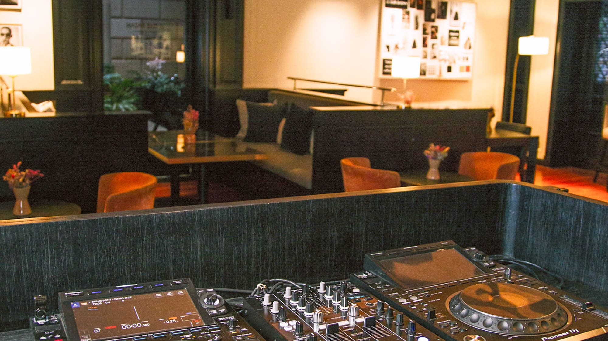 Consola DJ Pioneer en bar lounge de hotel moderno.