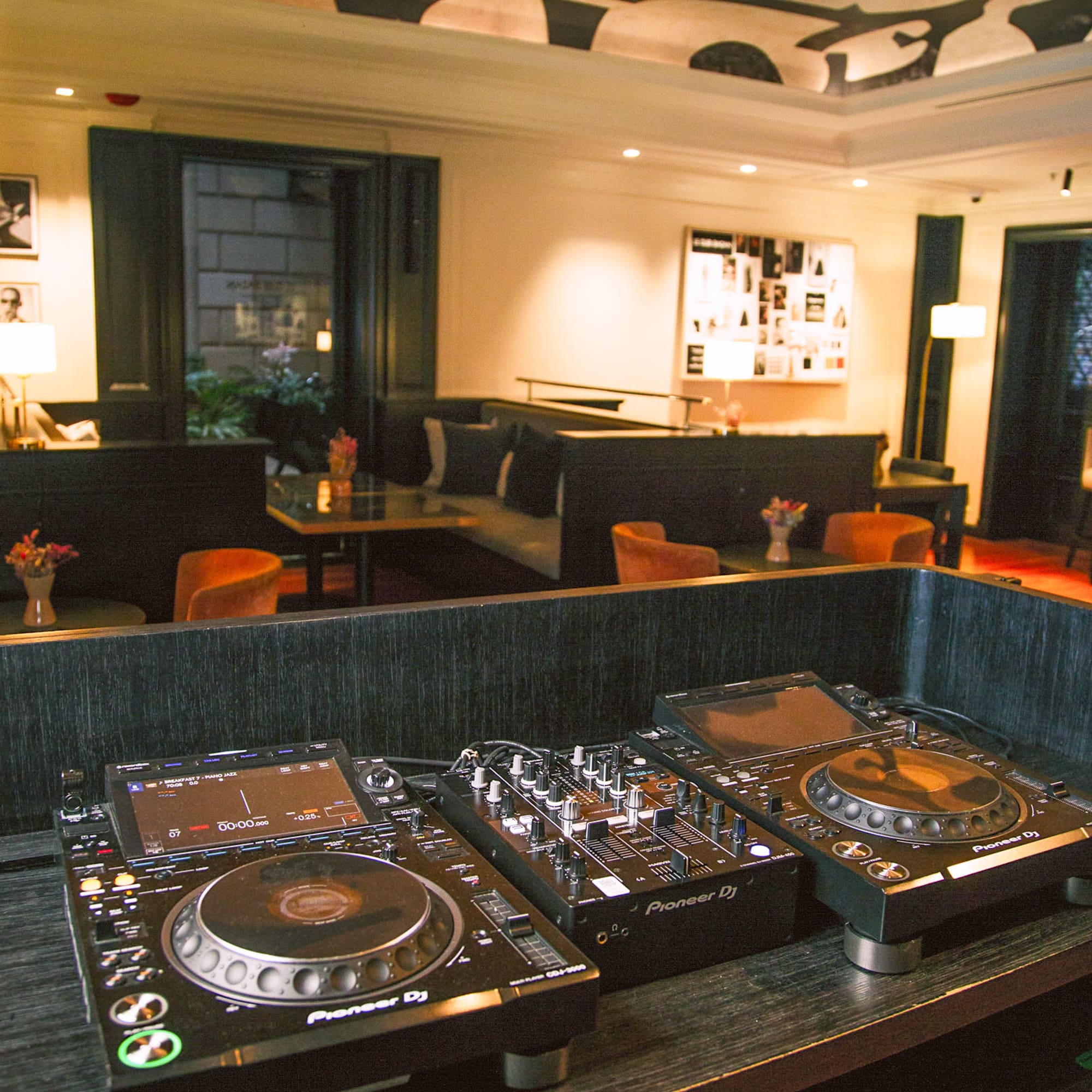 Consola DJ Pioneer en bar lounge de hotel moderno.