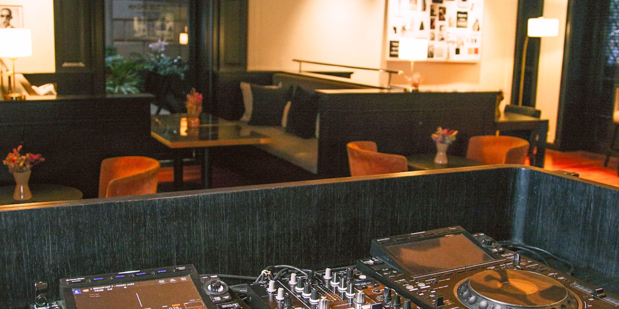 Consola DJ Pioneer en bar lounge de hotel moderno.