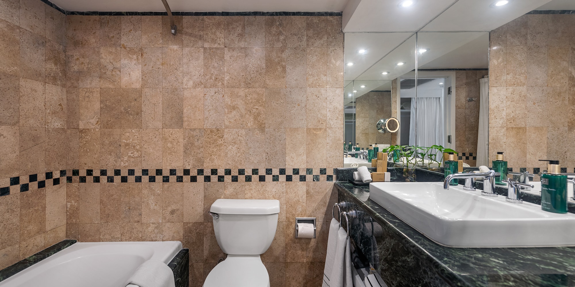 a bathroom with marble tiles and a toilet and tub