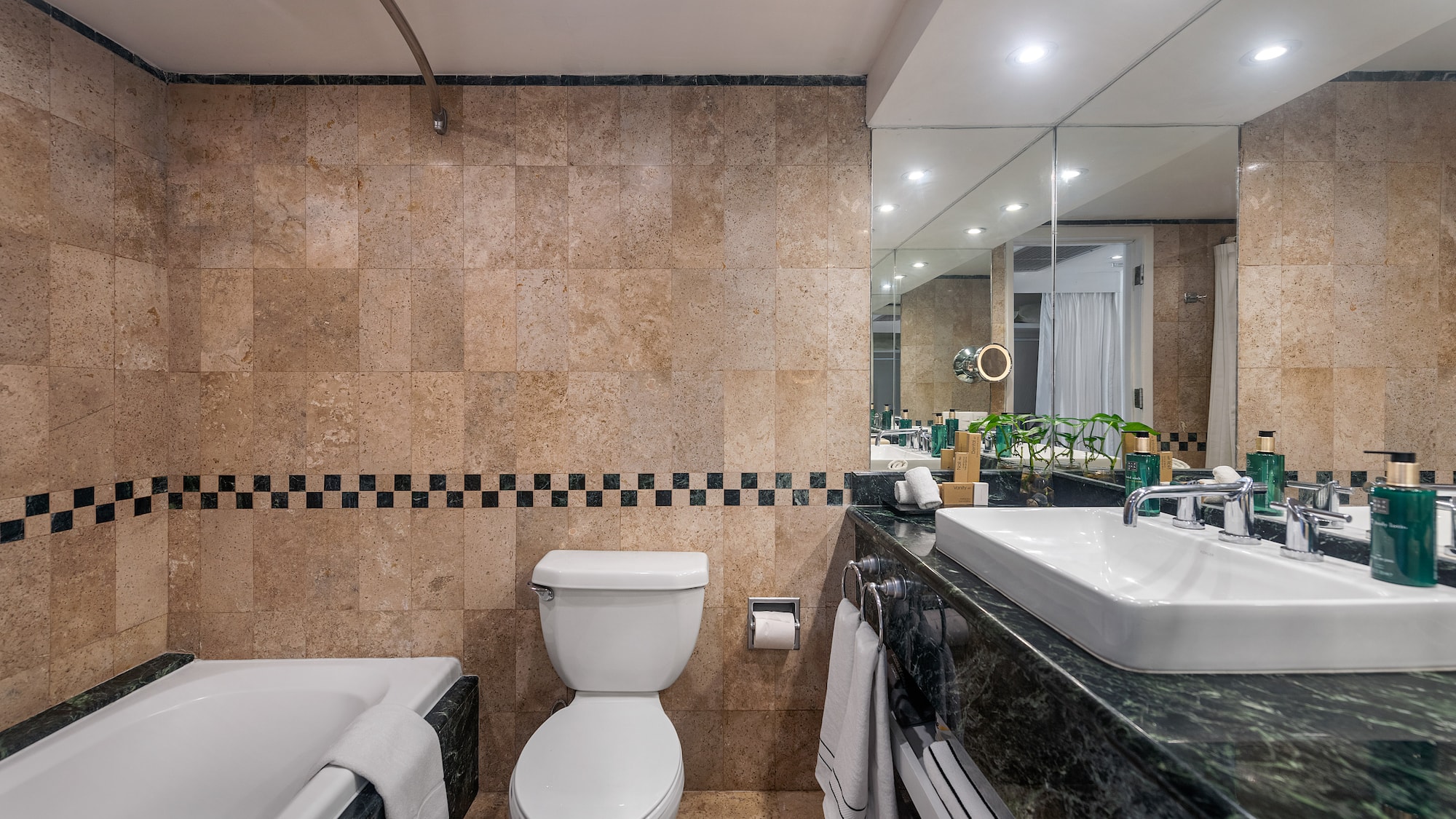 a bathroom with marble tiles and a toilet and tub