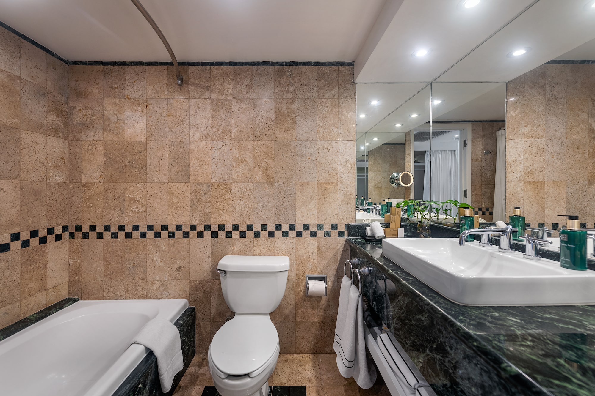 a bathroom with marble tiles and a toilet and tub