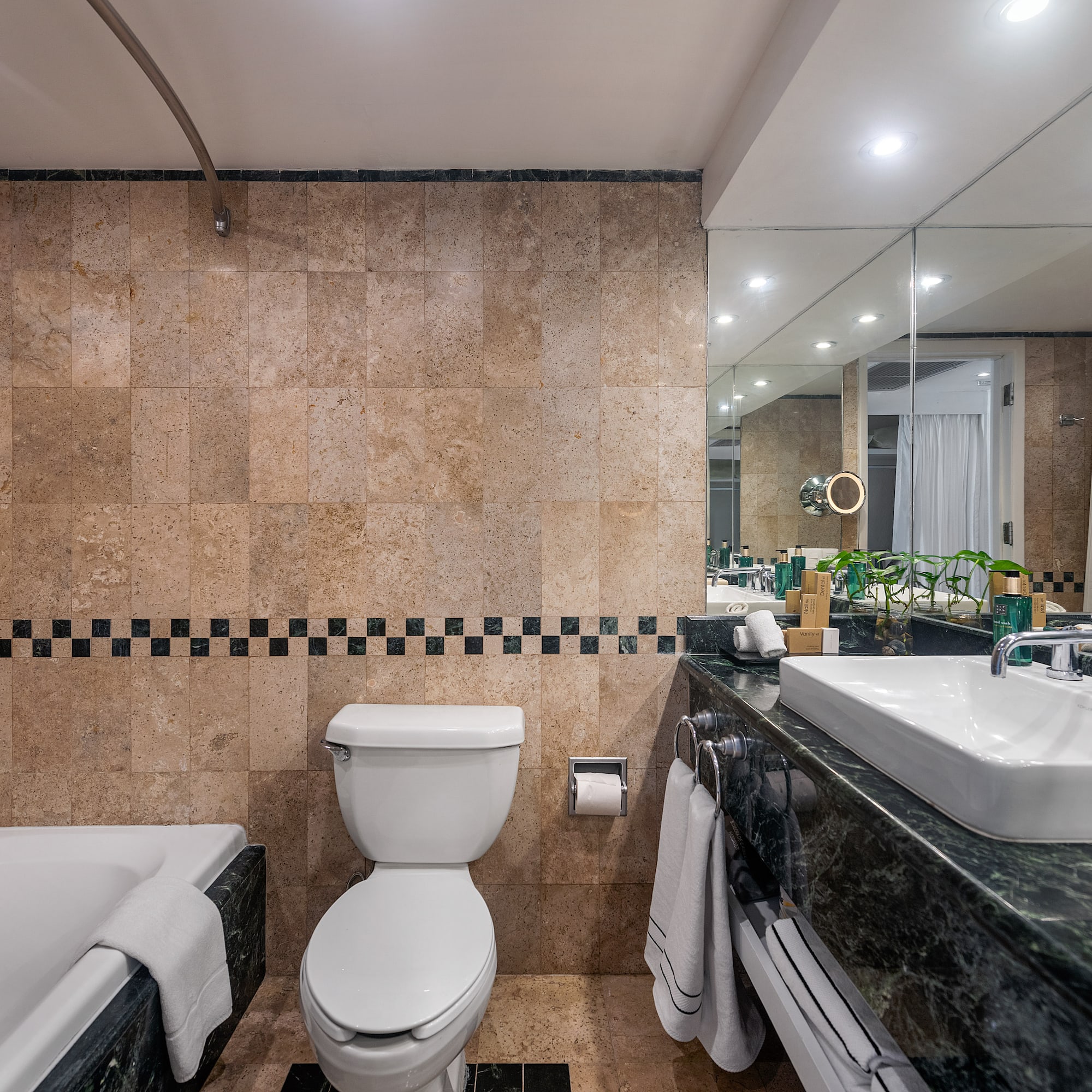 a bathroom with marble tiles and a toilet and tub