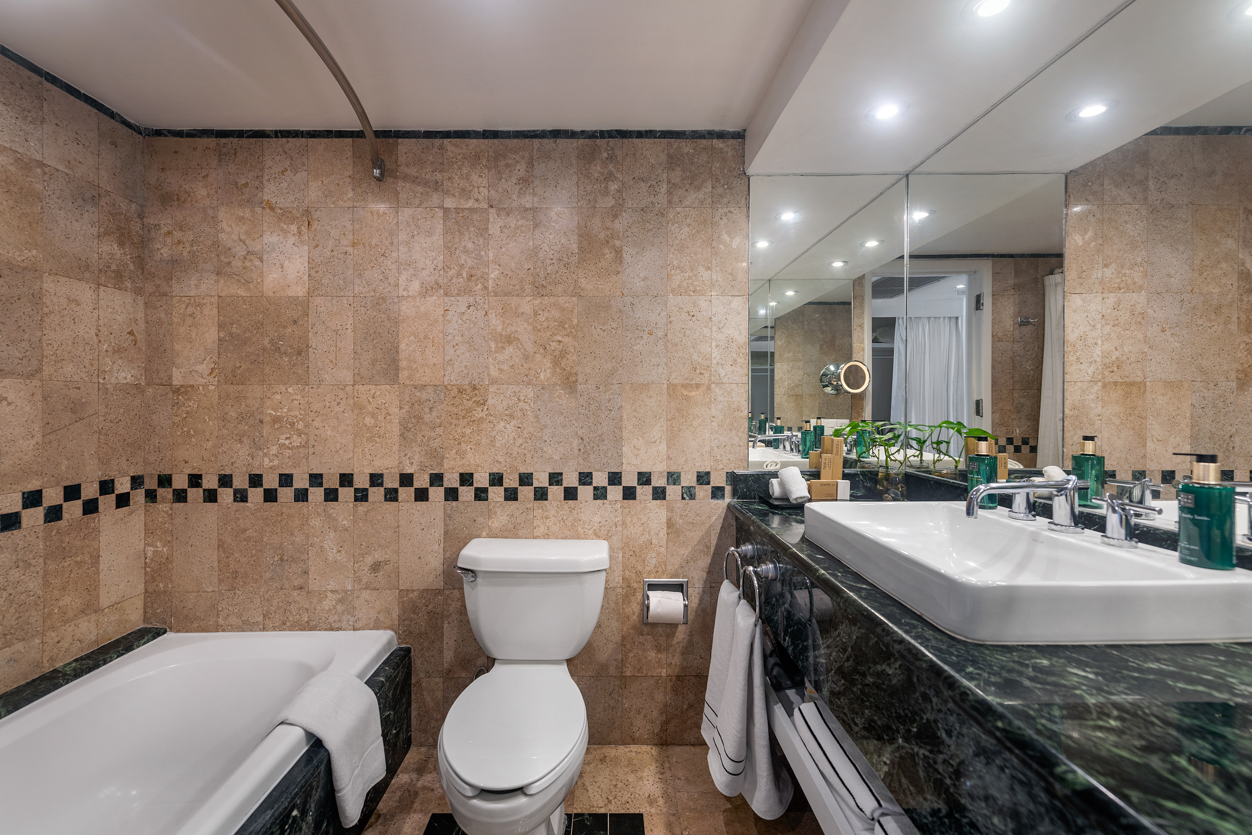 a bathroom with marble tiles and a toilet and tub