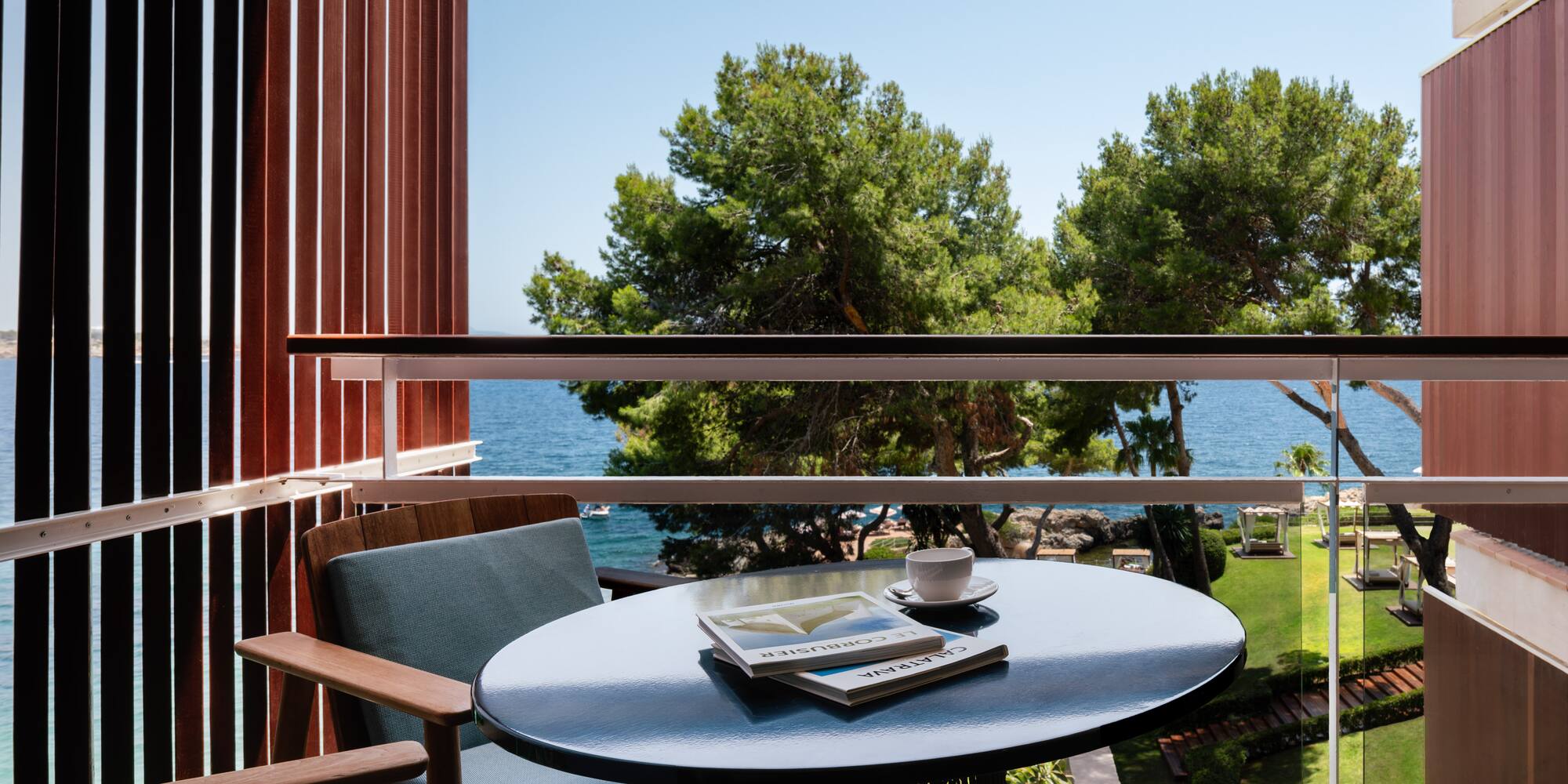 a table with a book and a cup on it outside of a balcony