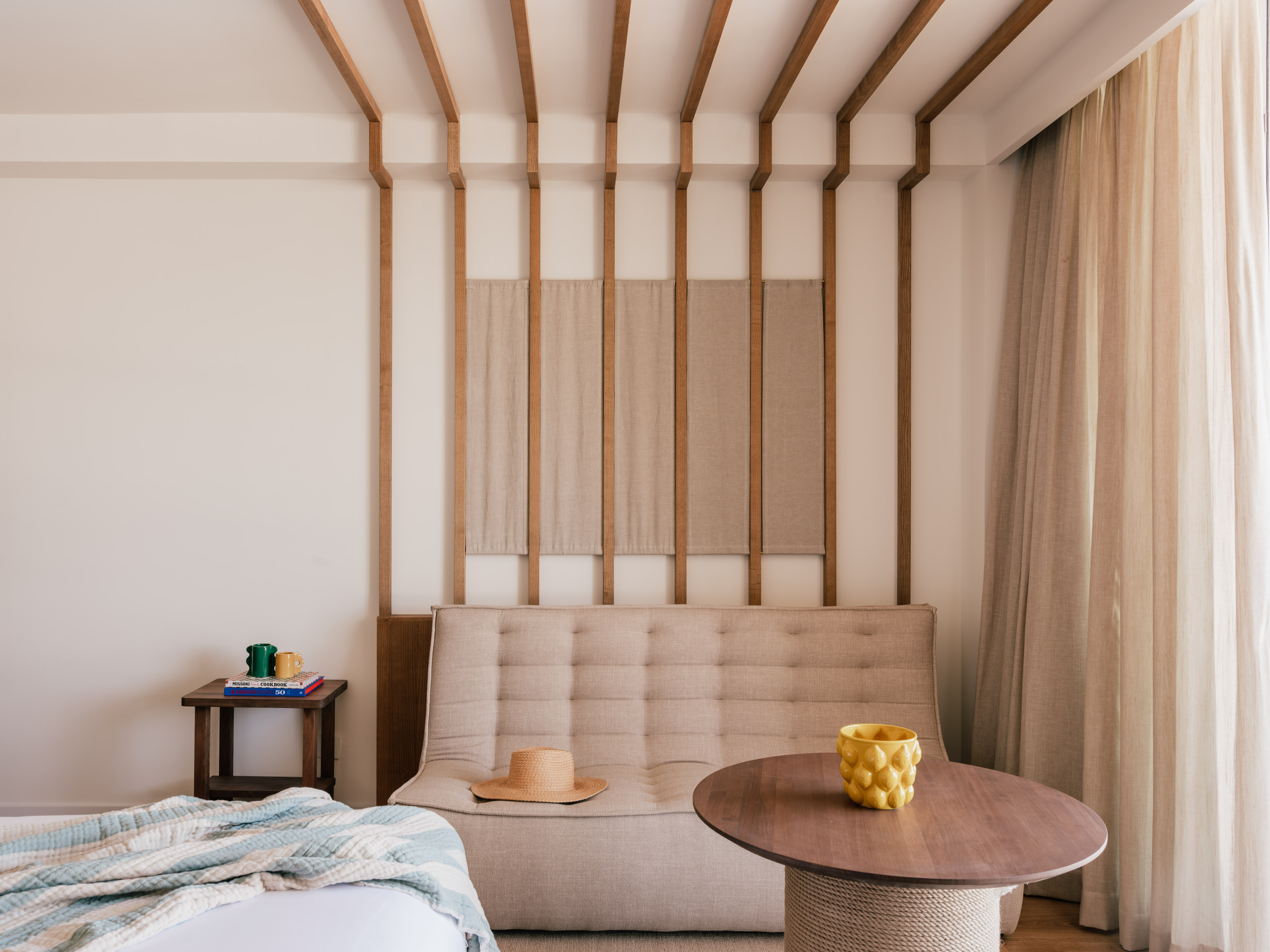 Modern room with neutral tufted sofa, wooden wall decor, and round coffee table.