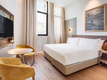 a room with a bed and chairs