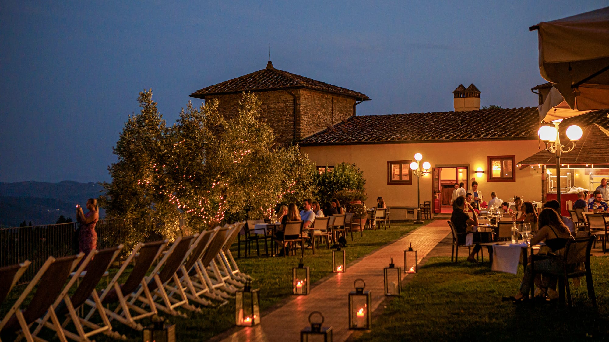 a group of people sitting at tables outside a building