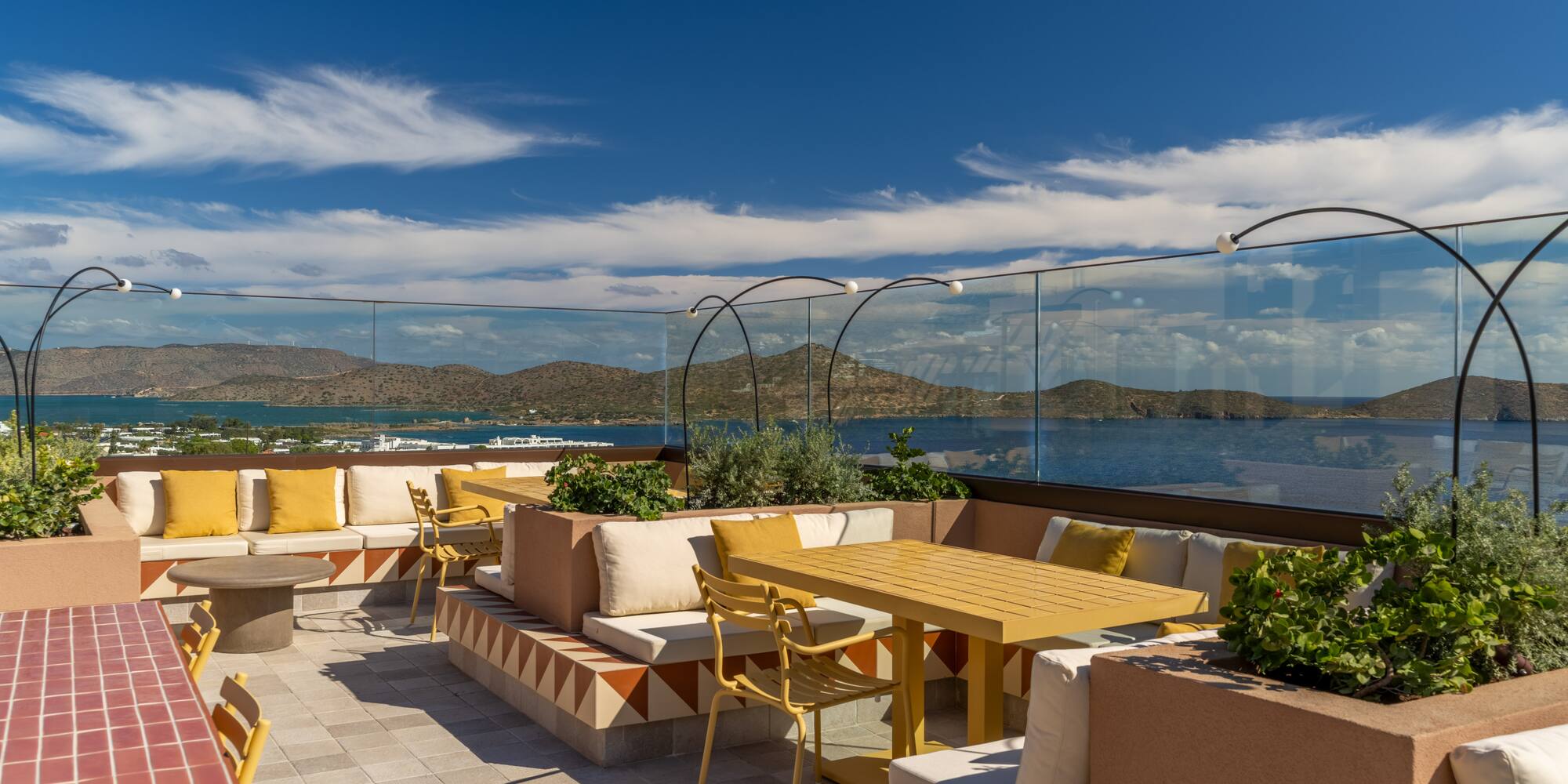 a patio with a table and chairs and a glass fence