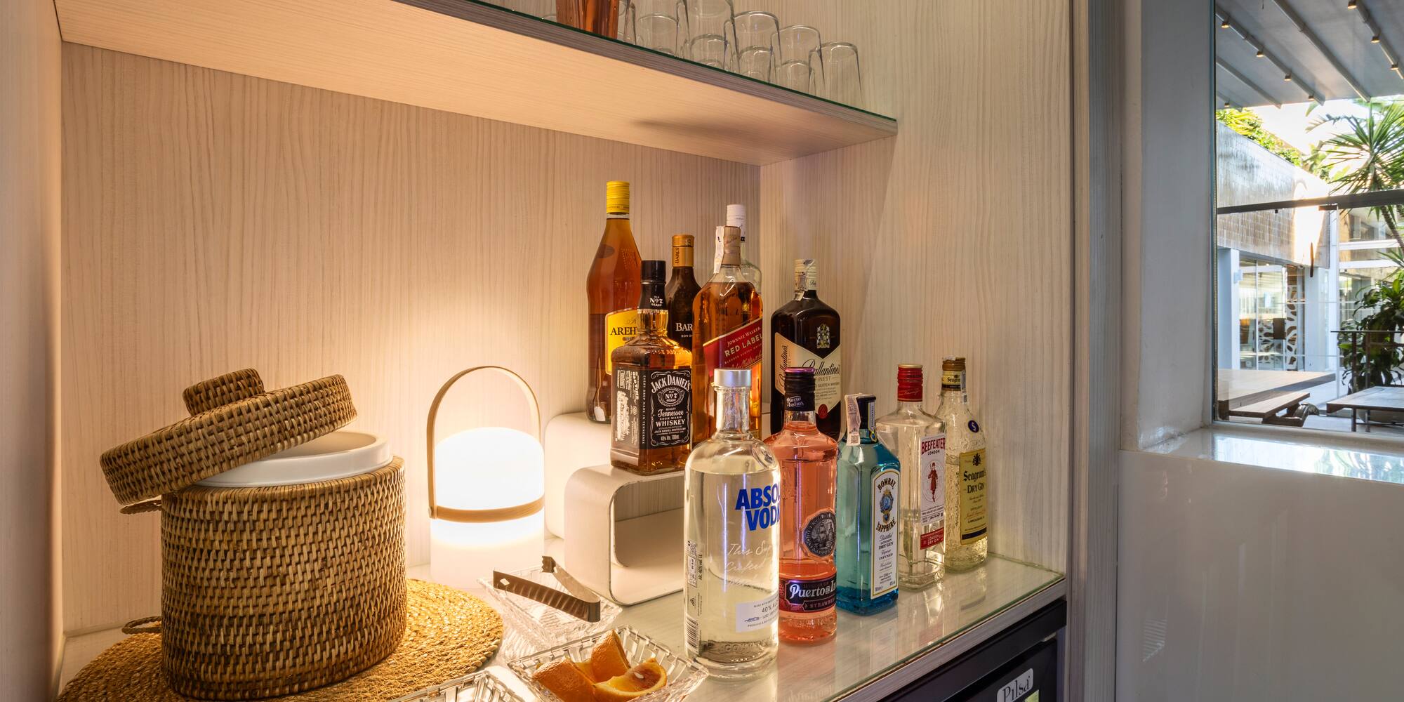 a shelf with bottles of alcohol and glasses