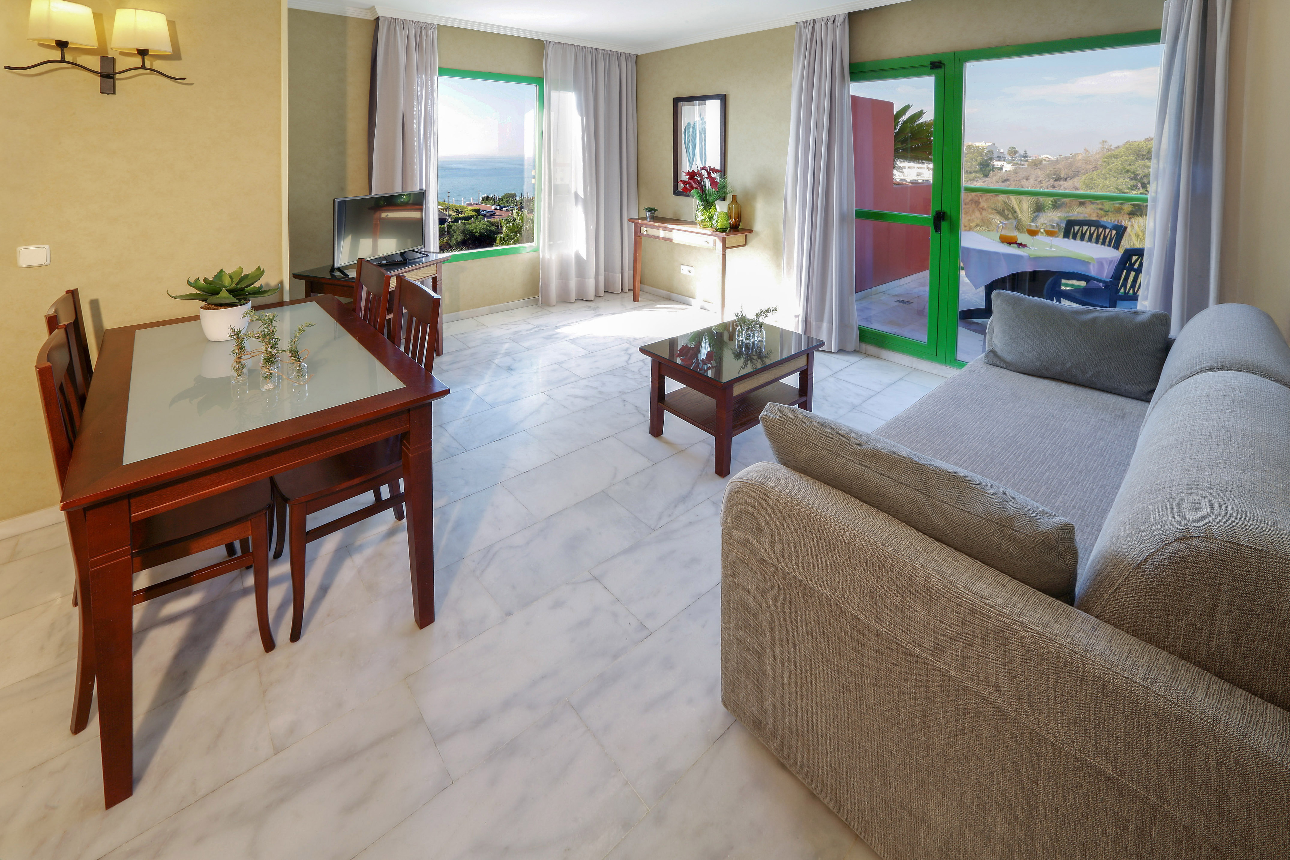 Modern living room, dining area, ocean view, private balcony, marble flooring.