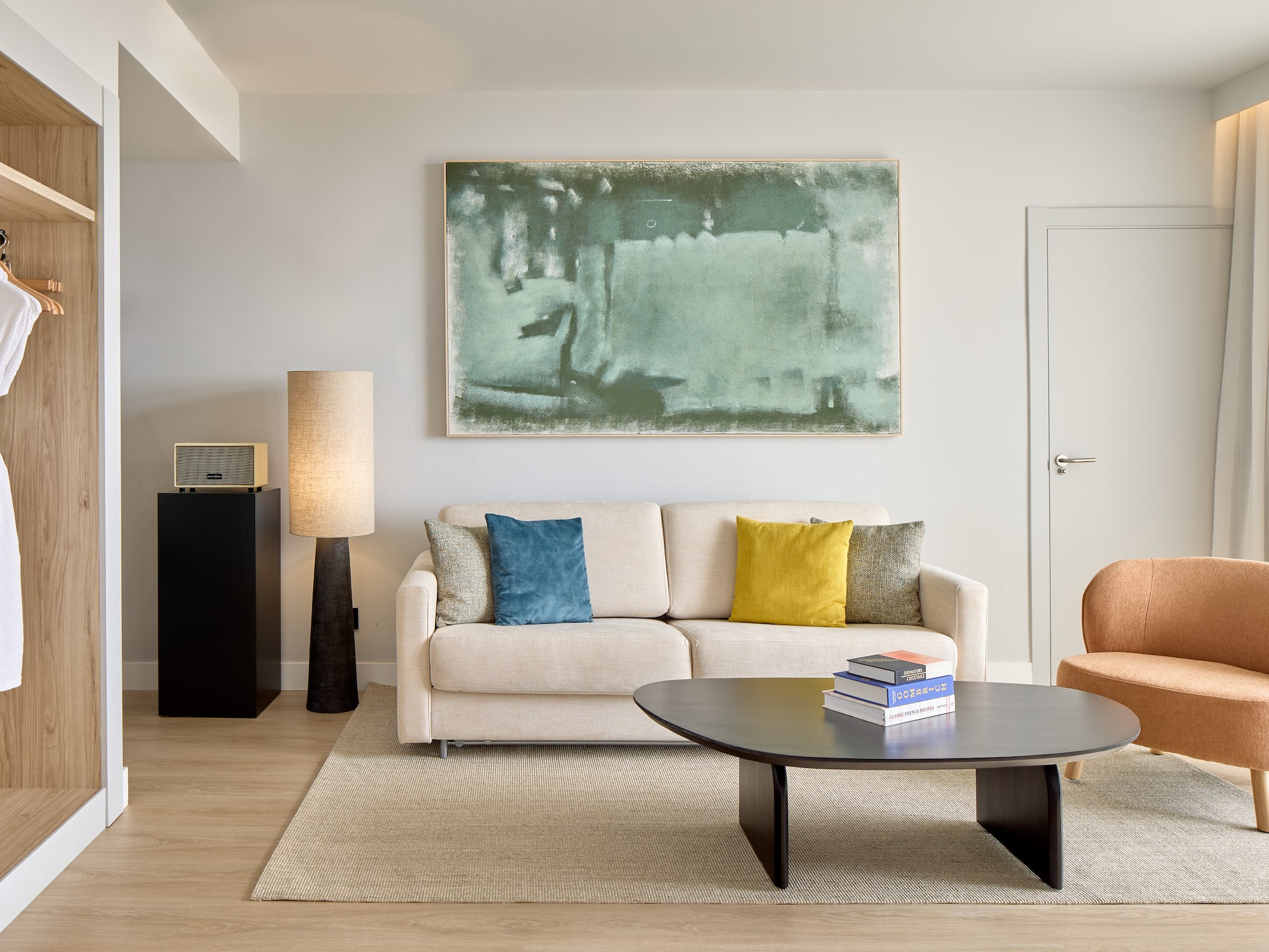 Salón moderno suite Meliá con sofá, sillón, mesa de centro y arte abstracto.