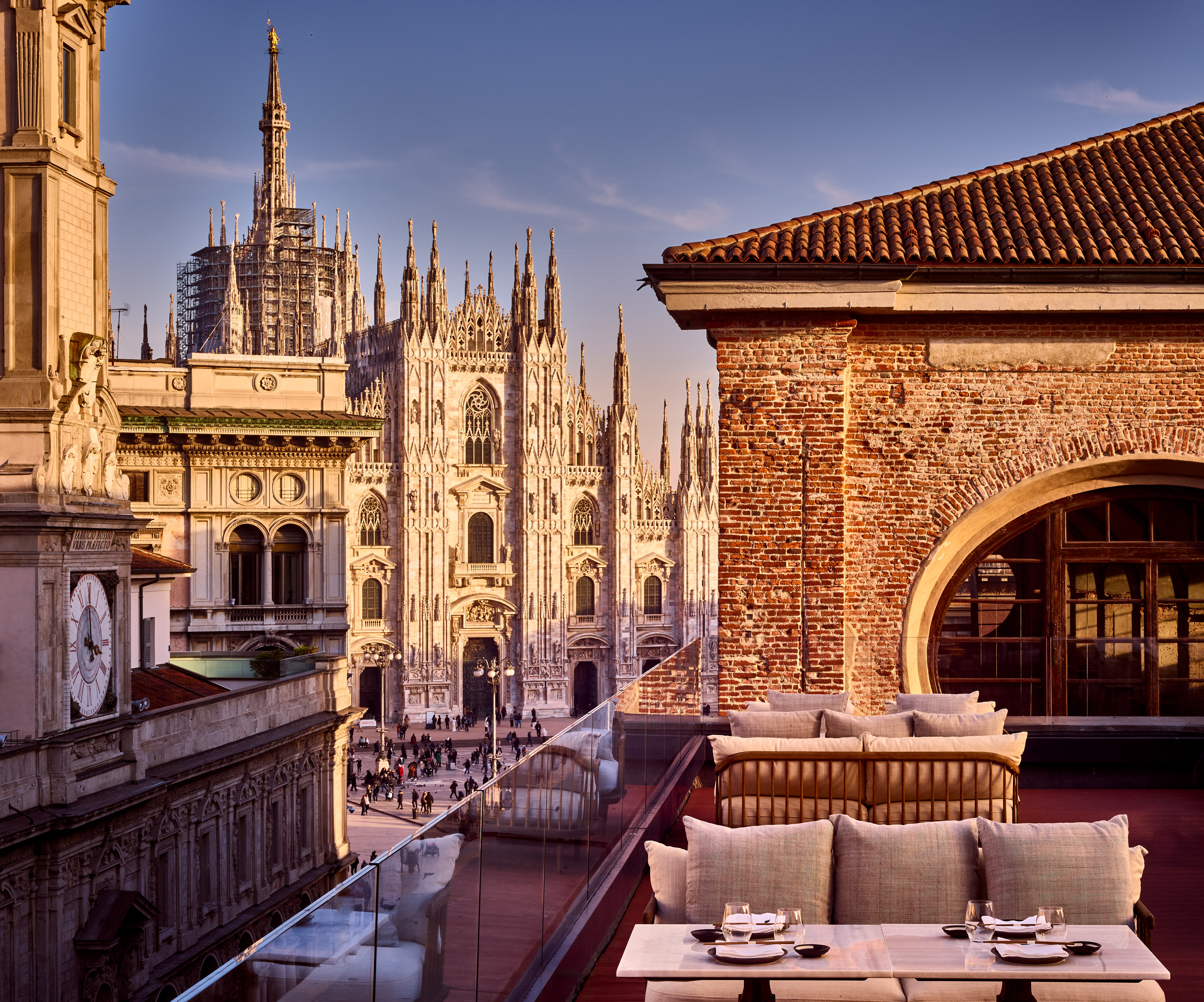 Milan Duomo cathedral from a modern rooftop terrace restaurant.