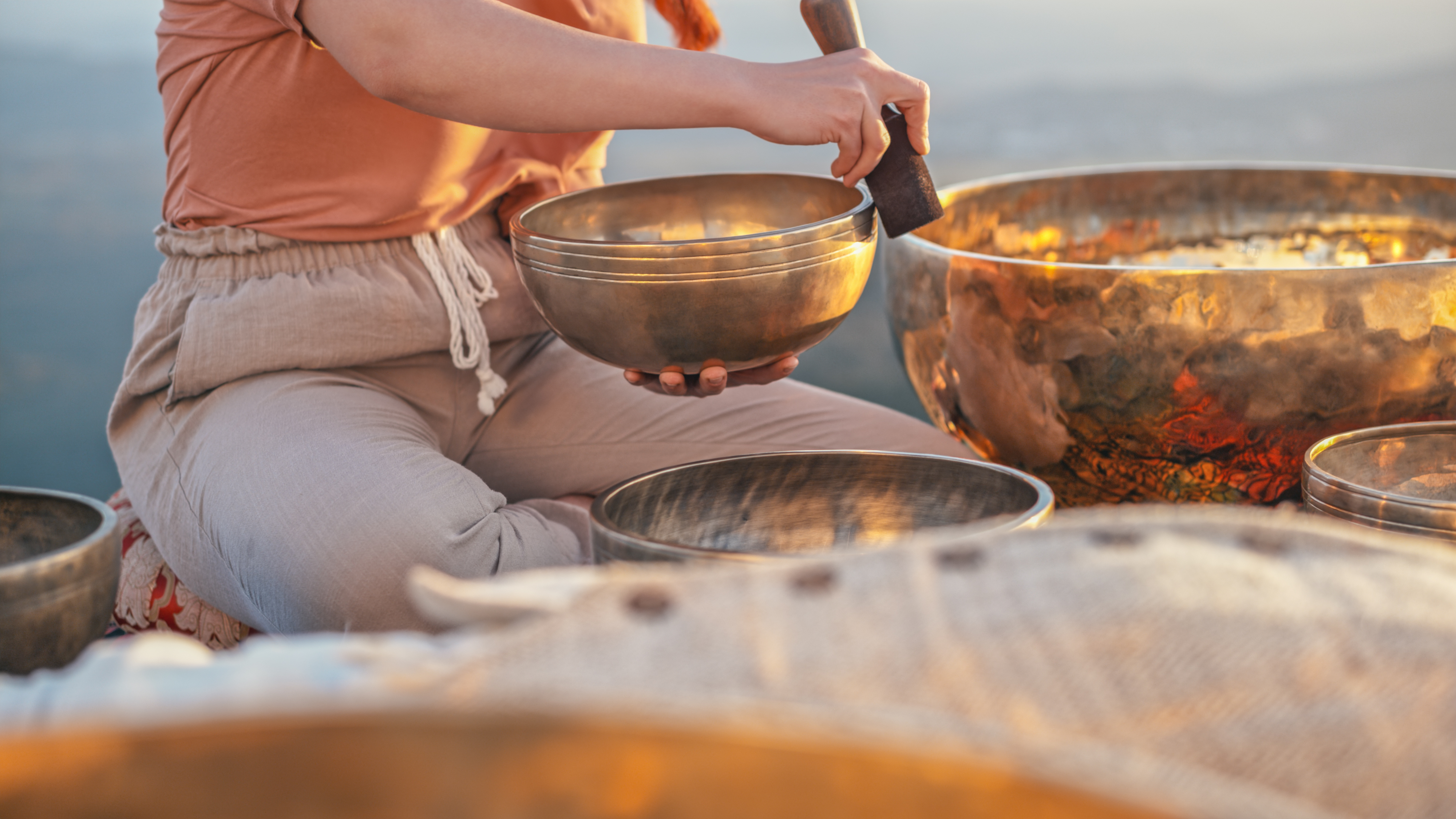 Person playing singing bowl for meditation and sound healing.