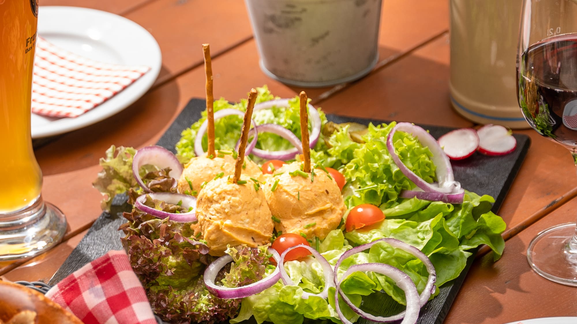 a plate of salad and a glass of beer on a table