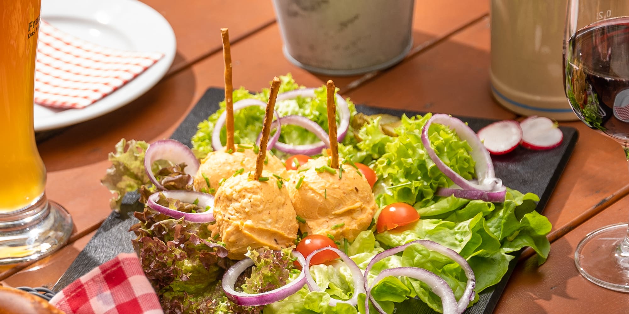 a plate of salad and a glass of beer on a table
