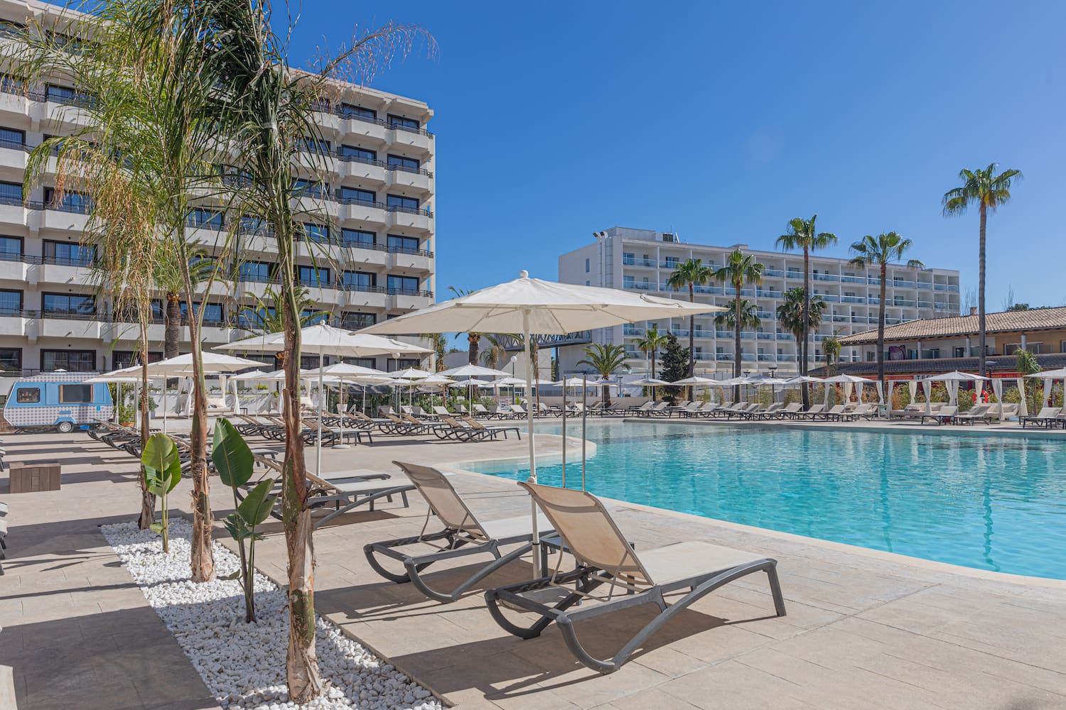 a pool with lounge chairs and umbrellas