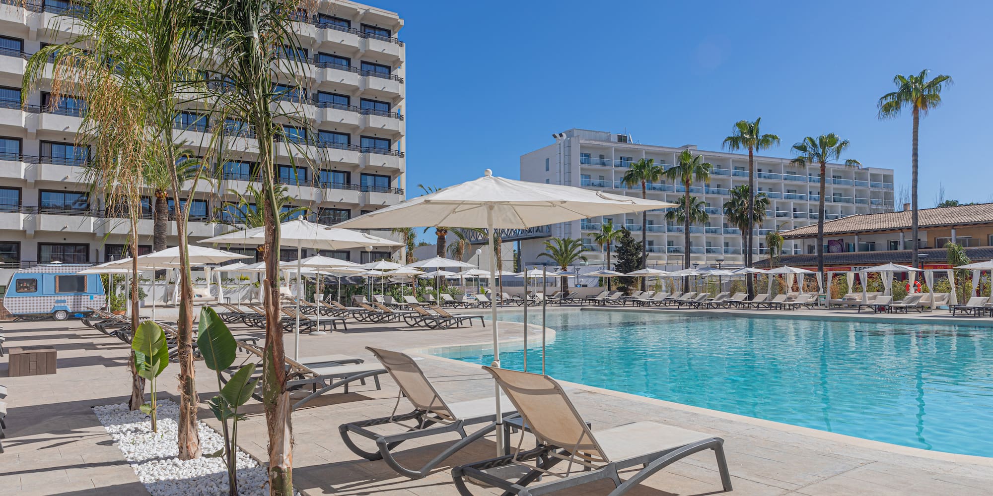 a pool with lounge chairs and umbrellas